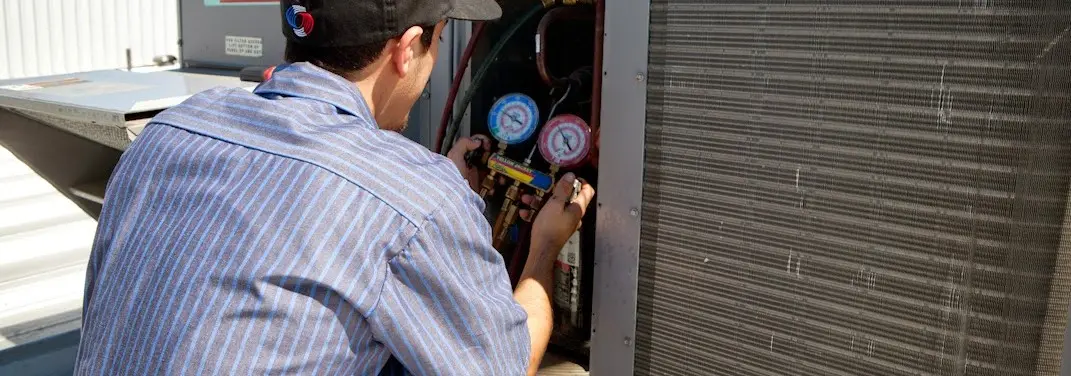 HVAC technician servicing a condenser unit in Jersey Village