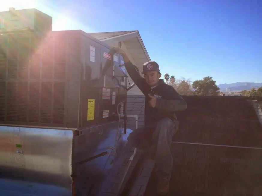 HVAC technician performing Heat Pump Repair on a rooftop unit in Jersey Village